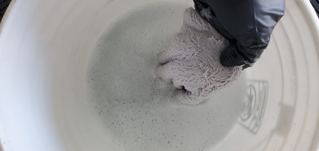 Microfiber towels soaking in the solution after use.